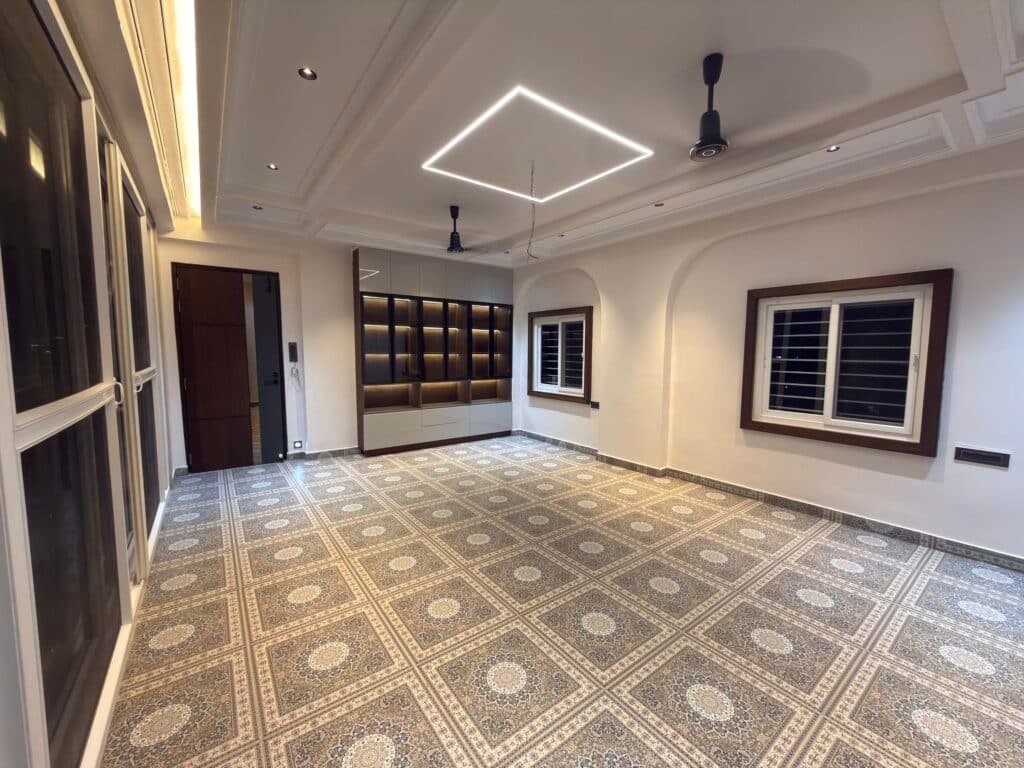 Modern living room interior with decorative flooring, false ceiling, built-in display shelves, and contemporary lighting