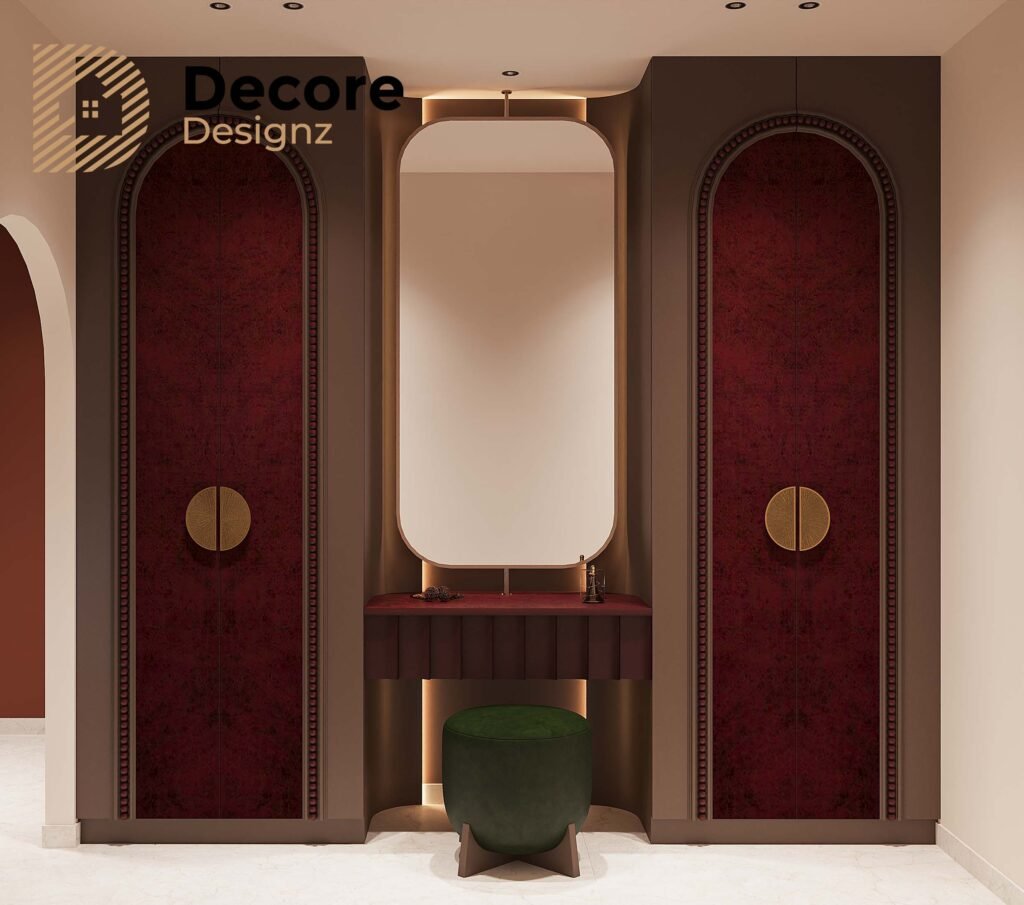 Luxury Bedroom Interior Design in Hyderabad: A Warm, Modern Master Bedroom 2 Luxury bedroom dressing area with a large backlit mirror, dark wood wardrobes, burgundy panels, gold accents, and a green upholstered stool.